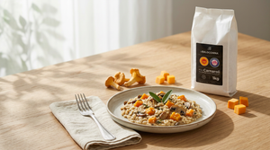 Piatto di risotto con zucca e funghi su una tavola in legno, con confezione di riso Carnaroli DOP da 1 kg e una forchetta accanto al piatto.